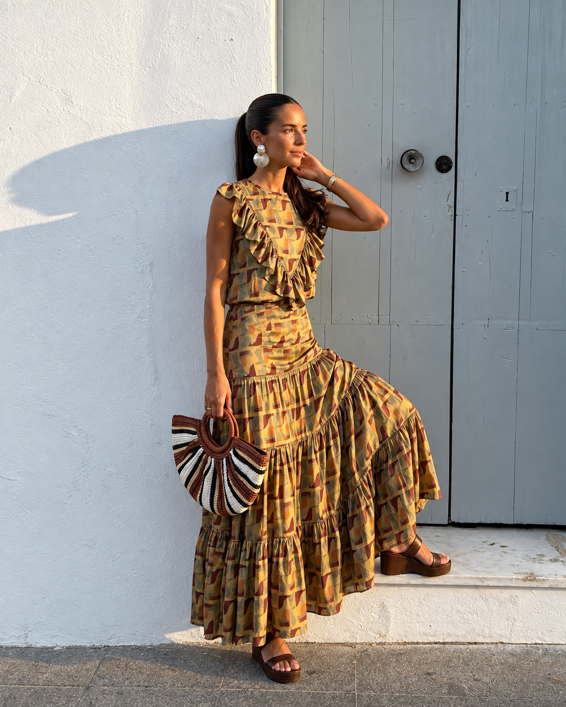 Modelo  con conjunto estampado en tonos bordó y verde, con sandalias chocolate y accesorios artesanales.