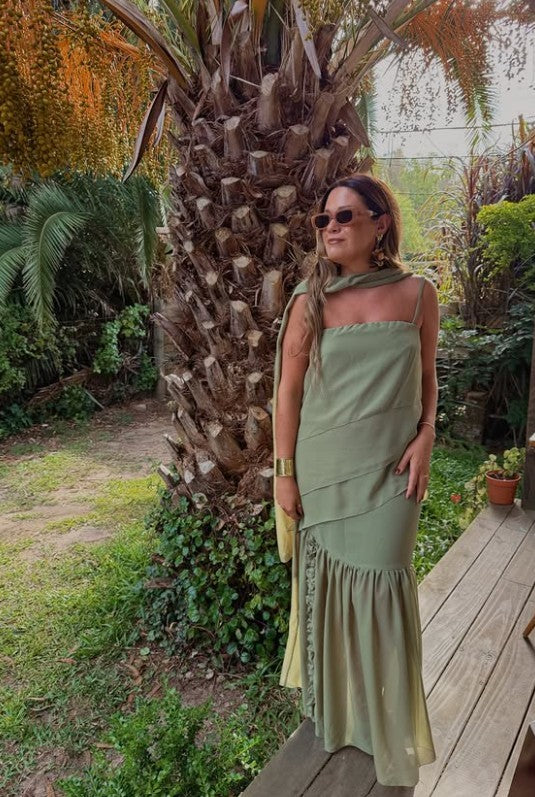 Modelo usando top de gasa verde con breteles regulables, combinado con falda larga al tono, en exterior