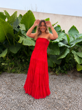 Modelo luciendo vestido largo strapless de encaje rojo con falda amplia y fruncida.